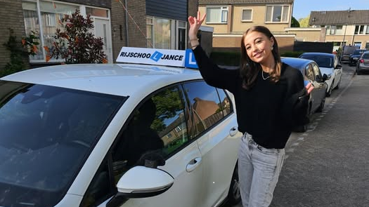 Noelle Stap bij lesauto